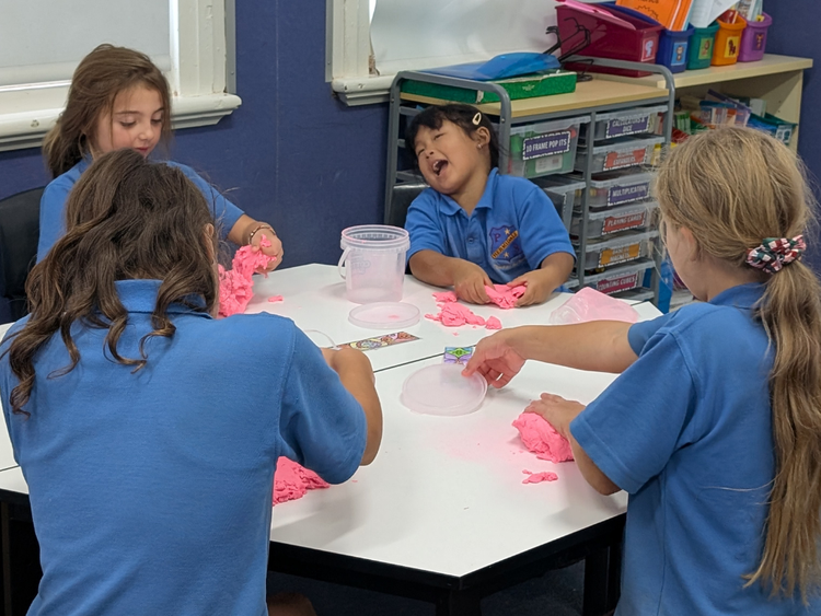 HPS students enjoying working with play dough in class